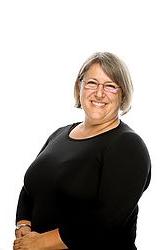 Kristin Fry stands in front of a white background. She smiles at the camera.